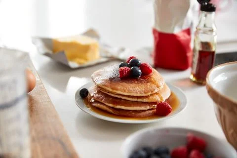 Stack Of Freshly Made Pancakes Or Crepes With Maple Syrup And Berries On Table Stock Photos