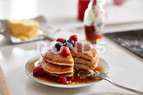 Stack Of Freshly Made Pancakes Or Crepes With Maple Syrup And Berries On Table Stock Photos