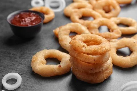 Stack of fried onion rings on table, closeup Stock Photos