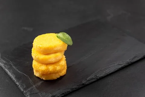 A Stack of Fried Polenta Discs, copy space for your text on the dark background Stock Photos