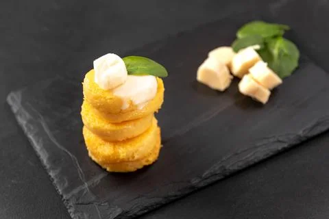 A Stack of Fried Polenta Discs, copy space for your text on the dark background 库存照片