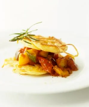 A stack of fried potato slices and ratatouille Foto stock