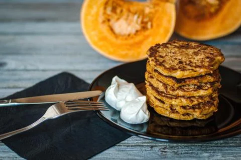 Stack of fried pumpkin pancakes served with natural yogurt for breakfast Stock Photos