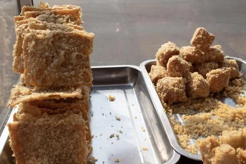 A stack of fried tempeh displayed at street food cart. Stock Photos