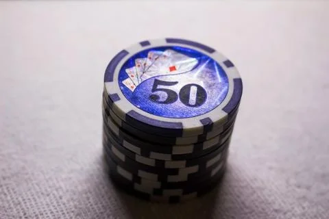 A stack of game chips with a denomination of fifty, against a dark background Stock Photos