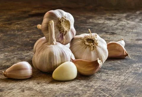 Stack Garlic Cloves and Garlic Bulb on old table Stock Photos