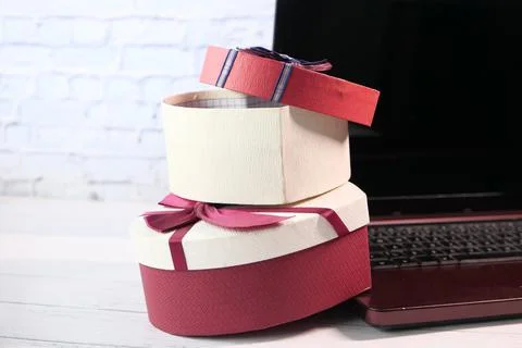 Stack of gift box and laptop on table 写真素材