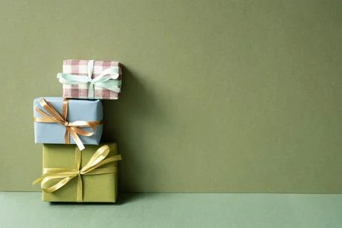 Stack of gift box on green table. khaki wall background Stock Photos