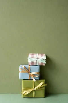 Stack of gift box on green table. khaki wall background Stock Photos