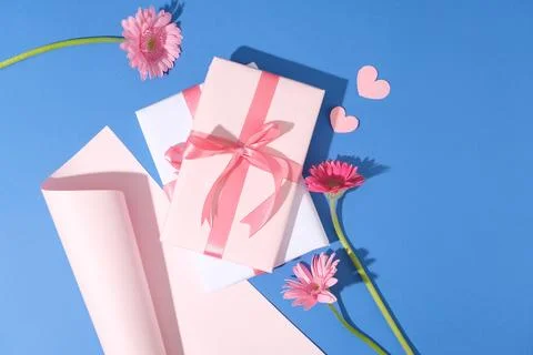 A stack of gift boxes decorated with a roll of paper, paper hearts in pink co 스톡 사진