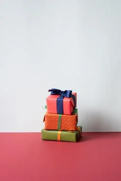 Stack of gift boxes on red desk. gray wall background Foto stock