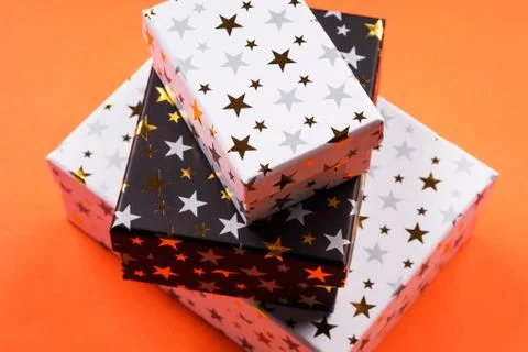 Stack of gift boxes with stars on orange Stock Photos