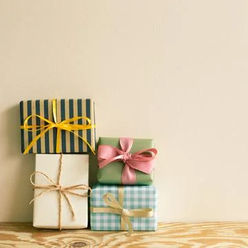 Stack of gift boxes on wooden table. beige wall background Stockfoto's