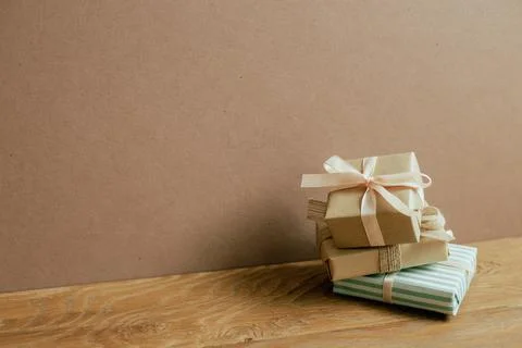 Stack of gift boxes on wooden table. brown wall background 写真素材