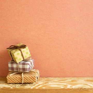 Stack of gift boxes on wooden table. red background Stack of gift boxes on... Stock Photos