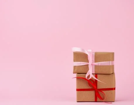 Stack of gifts in boxes wrapped in brown kraft paper and tied with silk ribbo Stock Photos