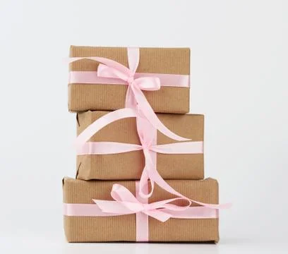 Stack of gifts in boxes wrapped in brown kraft paper and tied with silk ribbo Foto stock