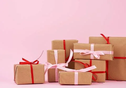 Stack of gifts in boxes wrapped in brown kraft paper and tied with silk ri... 스톡 사진