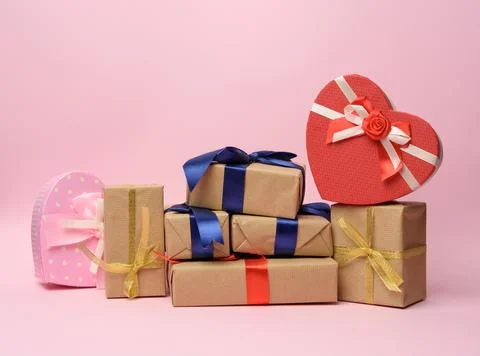 Stack of gifts wrapped in brown kraft paper and tied with silk ribbon, boxes  Stock Photos