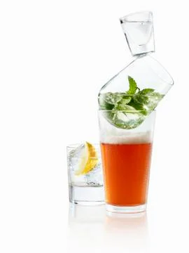 A stack of glasses with beer, mint and vodka with a gin and tonic next to it Foto stock