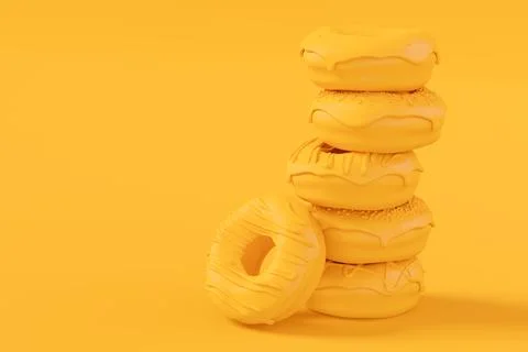 Stack of glazed donut with sprinkles on plain monochrome yellow color Stock Photos