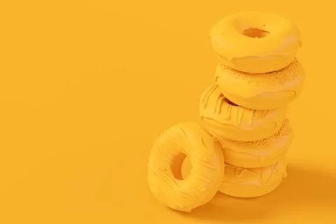 Stack of glazed donut with sprinkles on plain monochrome yellow color Stock Photos