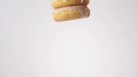 Stack of glazed donuts raining on white slow motion macro food studio 4K stock Stock Footage 337909764