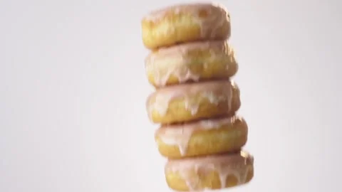 Stack of glazed donuts raining on white slow motion macro food studio 4K stock Stock Footage 337909865