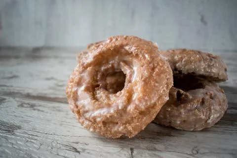 Stack of glazed donuts on rustic table Stock Photos