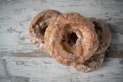 Stack of glazed donuts on rustic table Stock Photos