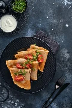 Stack of gluten free buckwheat flour crepes pancakes with cherry tomatoes and 스톡 사진