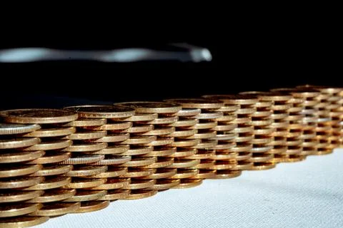 Stack of gold and silver dollar coins forming a border wall Foto stock