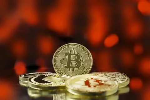 Stack of gold bitcoin coins with red bokeh background, bearish market Stock Photos