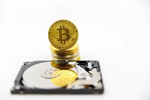 Stack of Gold bitcoin tokens on top of an open hard drive.Worldwide virtual i Foto stock