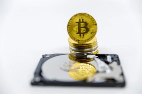 Stack of Gold bitcoin tokens on top of an open hard drive.Worldwide virtual i Stock Photos