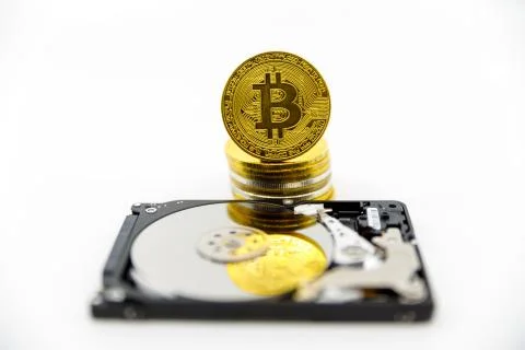 Stack of Gold bitcoin tokens on top of an open hard drive.Worldwide virtual i Stock Photos