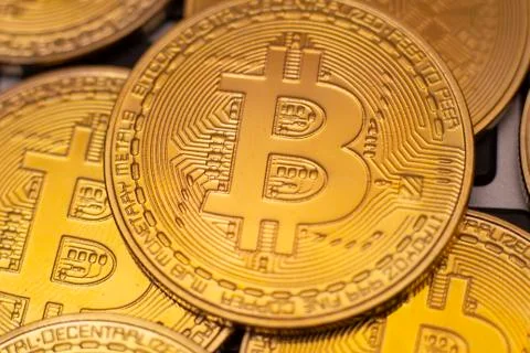 A stack of golden bitcoin coin on a silver keyboard of laptop. Virtual crypto Stock Photos