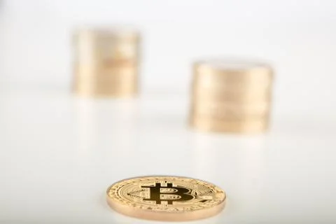 Stack of golden Bitcoins single of them laying on the gray surface.. Stock Photos