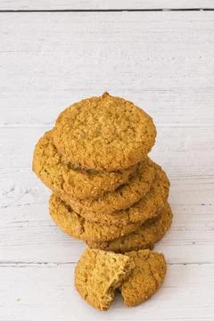 Stack of golden-brown cookies on white wood surface 스톡 사진
