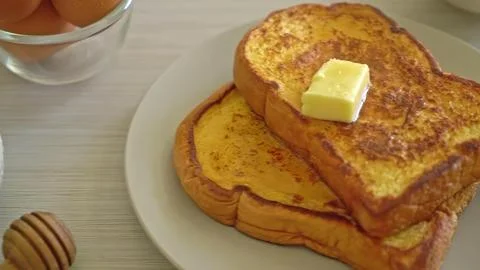 Stack of golden brown toasts with butter on top Stock Photos