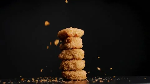 Stack of golden brown vegan chicken nuggets getting sprinkled with bread Stock Footage 178955863