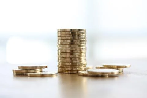 Stack of golden coins on white background with coins lying around on white Stock Photos