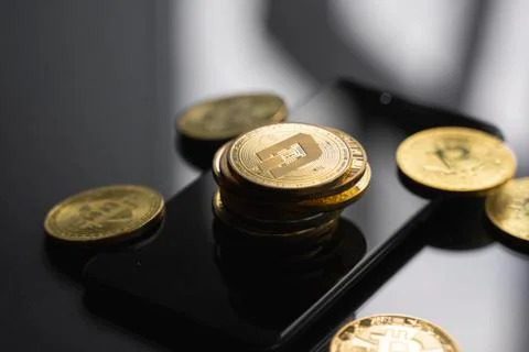 Stack of golden Dash bitcoin coin on a smartphone with a lot of bitcoins coins Stock Photos