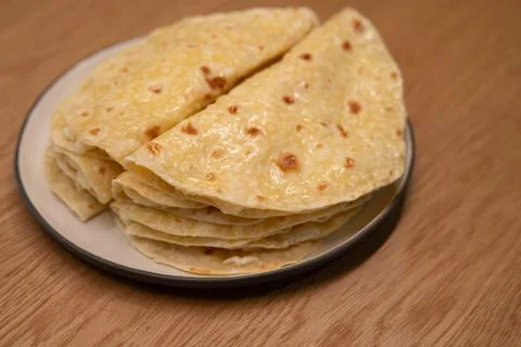 Stack of golden flatbreads resting on a ceramic plate Stock Photos
