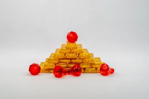 Stack of golden Lego blocks and red gems on a white background Stock Photos