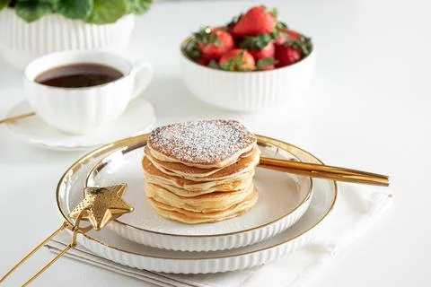 Stack of Golden Pancakes Dusted with Powdered Sugar with Strawberries and C.. Fotos de archivo