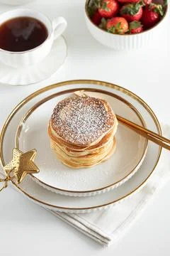 Stack of Golden Pancakes Dusted with Powdered Sugar with Strawberries and C.. 库存照片