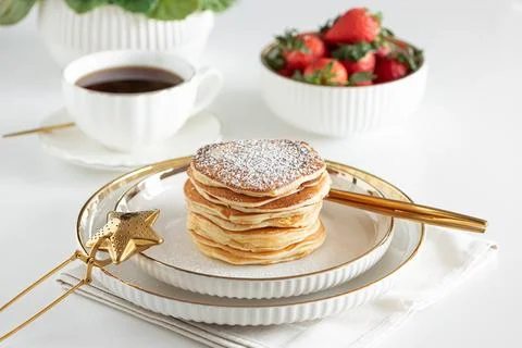 Stack of Golden Pancakes Dusted with Powdered Sugar with Strawberry and  Co.. 스톡 사진