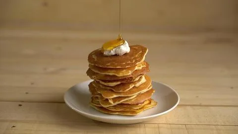 Stack of golden pancakes with syrup and butter on a plate Stock Photos