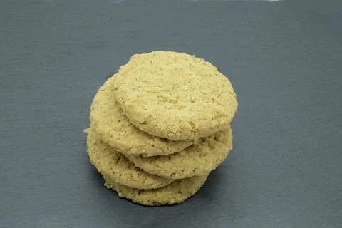 Stack of golden, textured cookies sits on gray surface 스톡 사진